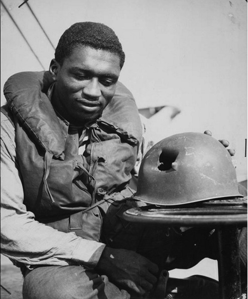Guarda costiero mostra como ficou seu capacete após ser atingido por estilhaços durante desembarque dos aliados na França, em 1944