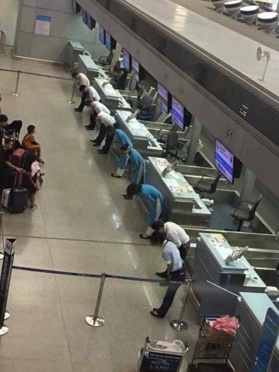 Funcionários de uma companhia aérea japonesa curvando-se para pedir desculpas aos passageiros pelo atraso nos vôos