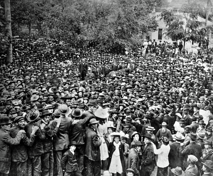Multidão se reúne para testemunhar o enforcamento de Henry Campbell, julgado e condenado por assassinar uma mulher e sua filha. Ele está de pé ao centro vestindo um terno escuro, Georgia, 1908