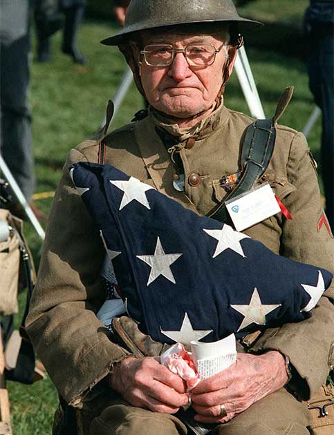 Joseph Ambrose, veterano da Primeira Guerra Mundial, acompanhando uma cerimônia oficial no Memorial dos Veteranos do Vietnã, em Washington DC, em 1982. Ambrose segura a bandeira que cobria o caixão do filho que morreu na Guerra da Coreia em 1951