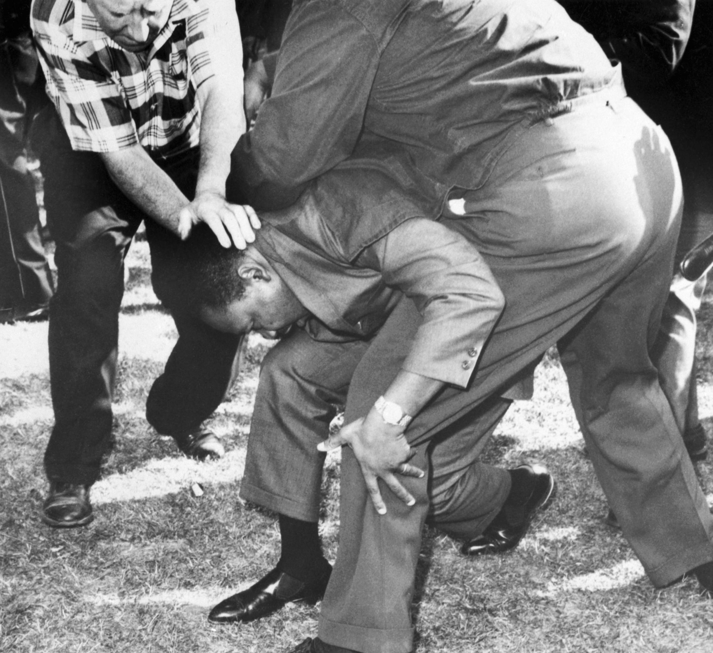Martin Luther King Jr protegido por assessores no meio de uma multidão hostil. Durante a marcha ele foi atingido por uma pedra na cabeça