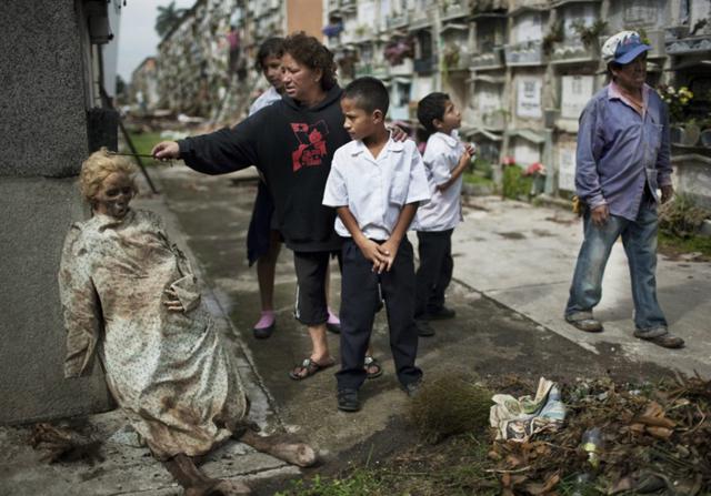 Corpo exumado de seu túmulo e deixado apoiado na parede, num cemitério da Guatemala, após parentes não conseguirem pagar as taxas do cemitério