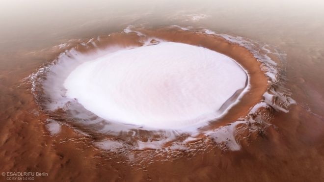 Cratera perto do pólo norte de Marte coberta por uma camada de gelo. Ela tem 82 km de diâmetro e tem 1,8 km de uma espessa camada de gelo
