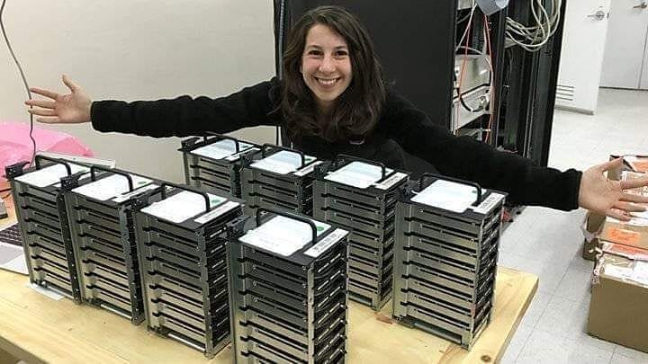 Katie Bauman posando com os 5 petabytes de dados necessários para a imagem de um buraco negro