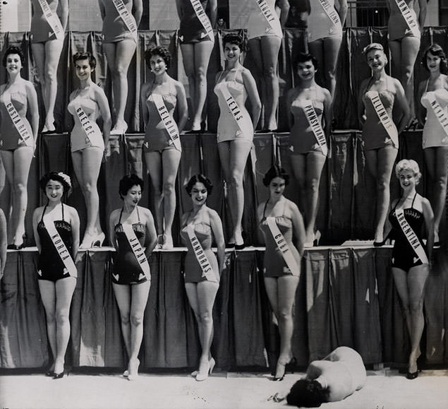 Todo mundo sorrindo, enquanto a Miss Nova Zelândia está desmaiada no chão durante uma sessão de fotos do concurso Misso Universo, em 1954