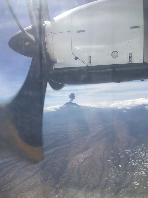 Avião passando próximo a um vulcão em erupção
