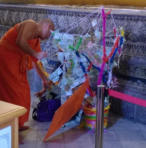 Monges tailandeses decoram árvore de dinheiro com notas. Ninguém se atreve a mexer no dinheiro