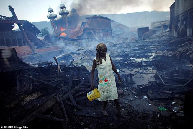 Mulher percorrendo o que sobrou do mercado de Port-au-Prince, Haiti, em 29 de janeiro de 2010. Um terremoto de magnitude 7 atingiu a ilha do Caribe duas semanas antes, matando 300 mil pessoas
