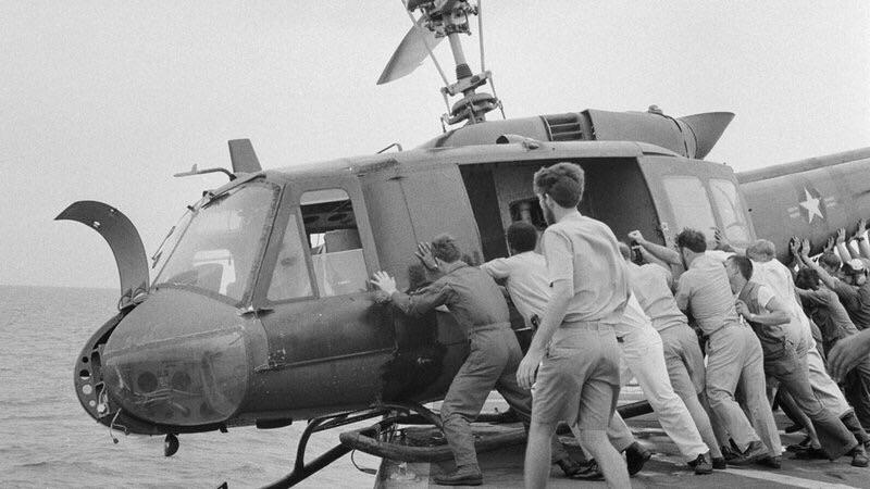 Soldados americanos empurram helicóptero para o mar a fim de obter mais espaço durante a retirada do Vietnã, 1975