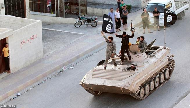 Combatentes do Estado Islâmico participando de desfile militar pelas ruas da província de Raqqa, norte da Síria, em 30 de junho de 2014. O Estado Islâmico assumiu a cidade, tornando-a capital do chamado califado, até serem expulsos por líderes da coalizão, em 2017