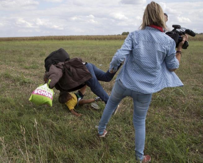 Petra Laszlo, câmera da N1TV, coloca o pé e derruba um migrante que levava uma criança nos braços tentando fugir das autoridades em Roszke, na Hungria. Ela foi demitida pela emissora