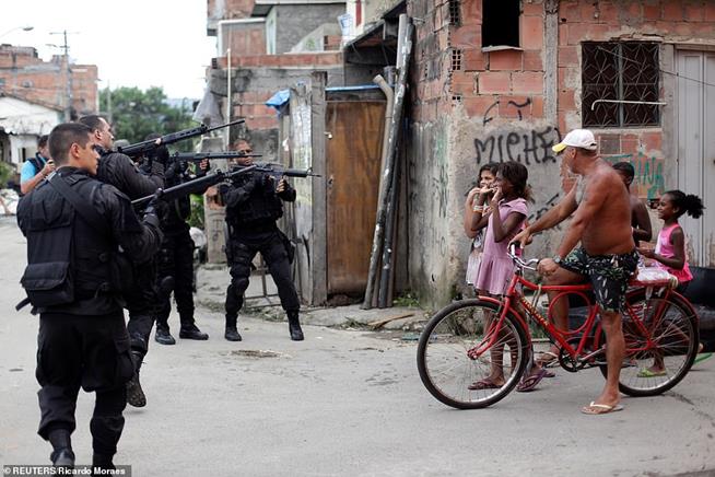 Moradores da favela da Maré, no Rio de Janeiro, observando policiais durante programa de pacificação, em 26 de março de 2014