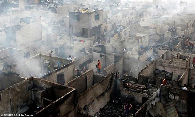 Moradores vasculham as ruínas de suas casas após incêndio na cidade de Makati, Manila, Filipinas. O incêndio, ocorrido em 19 de abril de 2011, foi iniciado por um curto-circuito e rapidamente se espalhou atingindo dezenas de casas