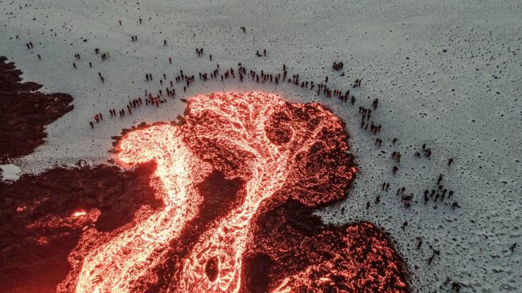 Pessoas observando lava decorrente de vulcão na Islândia