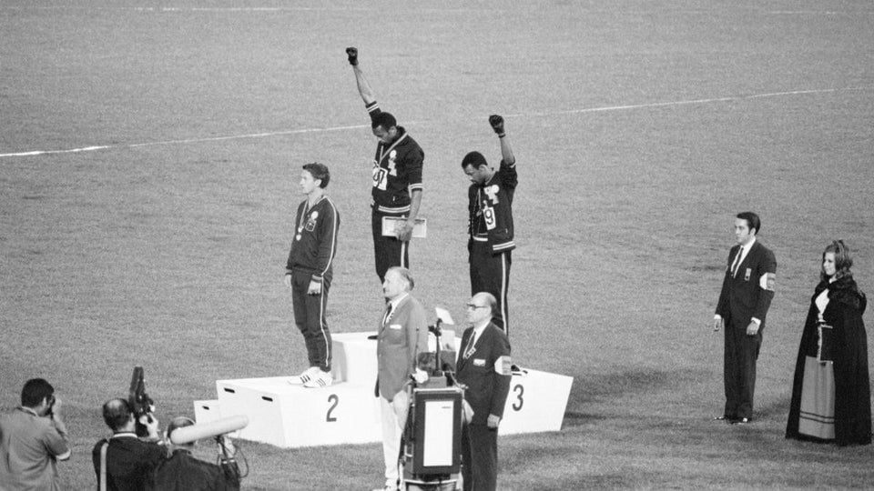 Nas Olimpíadas de 1968, Tommie Smith e John Carlos levantam seus punhos em saudação Black Power para destacar a desigualdade racial nos Estados Unidos.