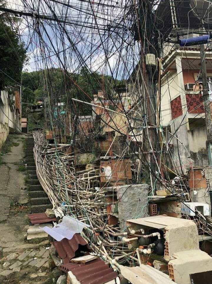 Foto tirada no complexo de favelas do Lins, na zona norte do Rio de Janeiro. Moradores instalam canos e fios para fazerem água e energia chegarem a suas casas no alto do morro.