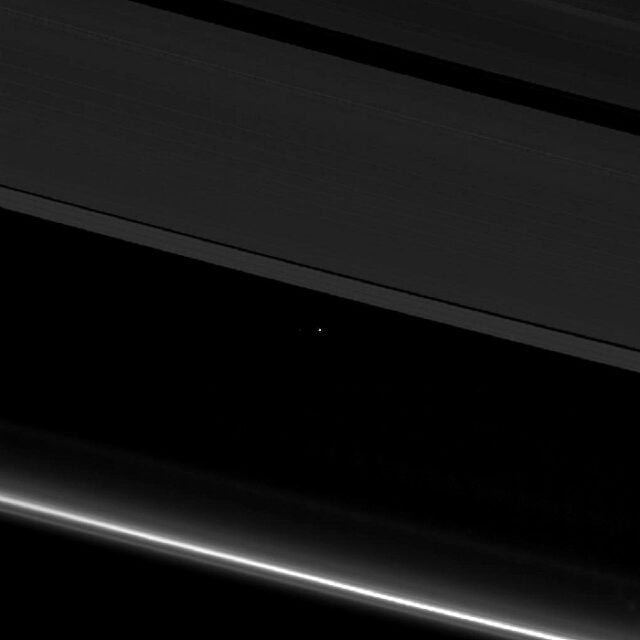 Este pequeno ponto no centro da imagem é a Terra. Uma partícula de poeira entre os anéis de Saturno, fotografada pela espaçonave Cassini a uma distância de 1,4 bilhão de quimômetros.