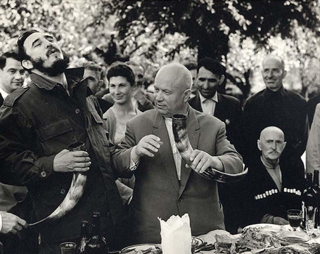 Festa na Geórgia com presença do ex-líder cubano Fidel Castro e Nikita Khrushchev, ambos bebendo vinho em uma caneca tradicional em forma de chifre, 1963.