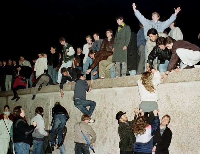 10 de novembro de 1989: alemães orientais escalam o Muro de Berlim pela primeira vez sem medo de serem baleados.
