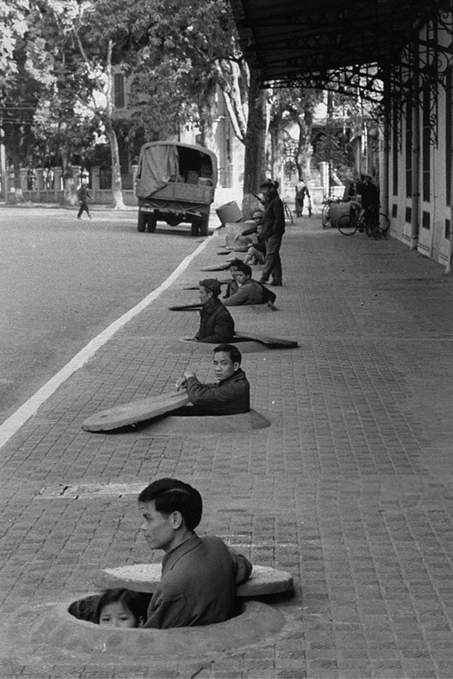 Moradores da cidade vietnamita de Hanói se abrigam durante um ataque aéreo, em 1967.