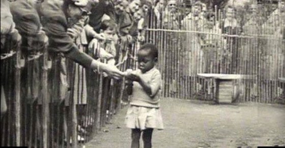 Menina sendo alimentada em um zoológico humano - Feira Mundial de 1958 - Bélgica. Neles, pessoas brancas observavam negros em cativeiro, como animais.