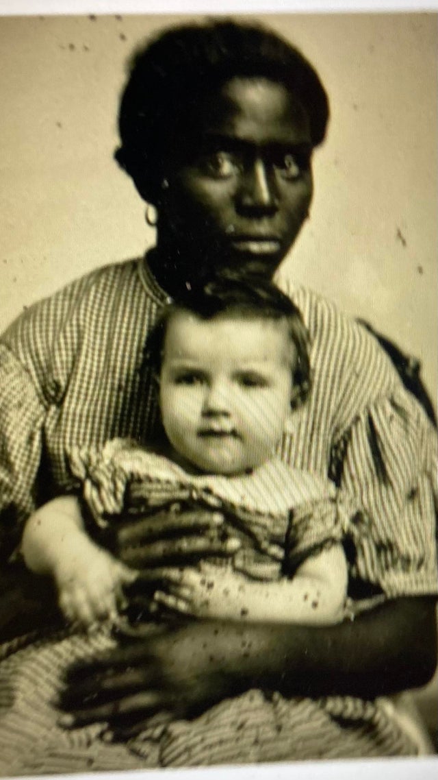 Uma enfermeira escravisada chamada Louisa, segurando uma bebê que seria sua 