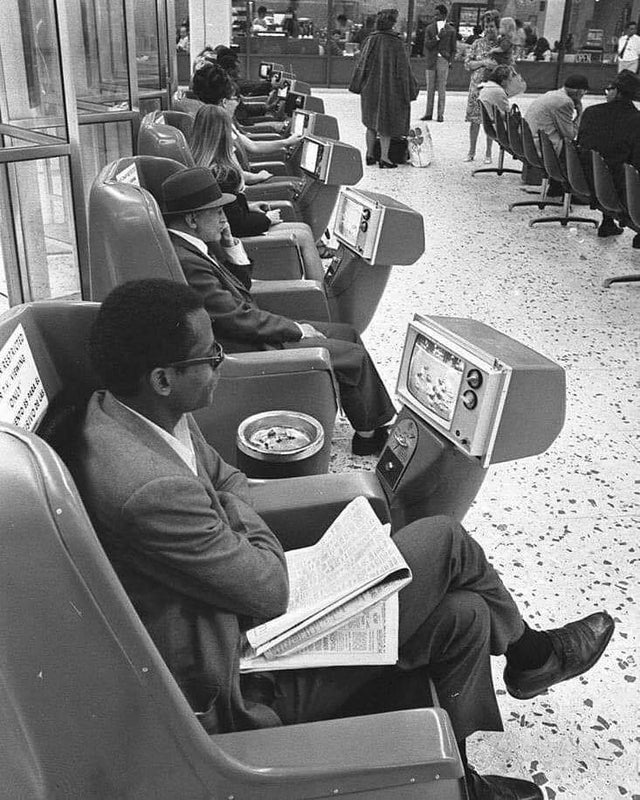 Passageiros aguardando a hora do embarque enquanto assistem TVs que funcionavam com moedas na estação rodoviária Grayhound, em Los Angeles, 1969.