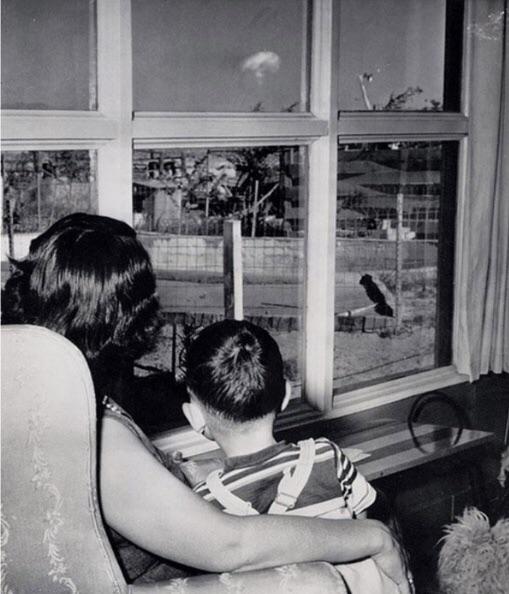 Uma mãe e seu filho observando uma nuvem em formato de cogumelo gerada por teste nuclear em Las Vegas, Nevada, 1953.