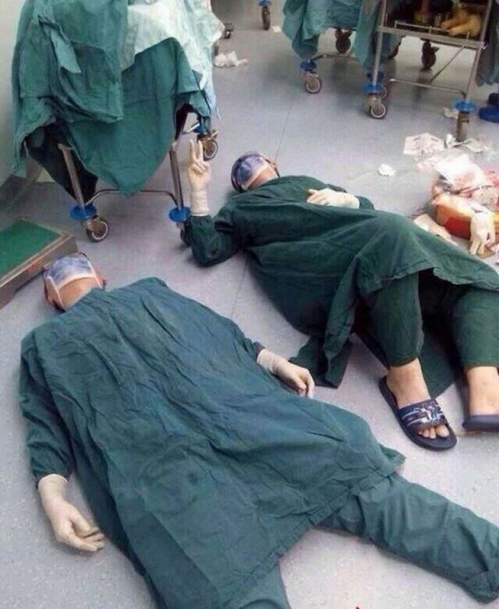 Dois cirurgiões exaustos após remover com sucesso um conjunto de tumores cerebrais durante cirurgia de 32 horas.