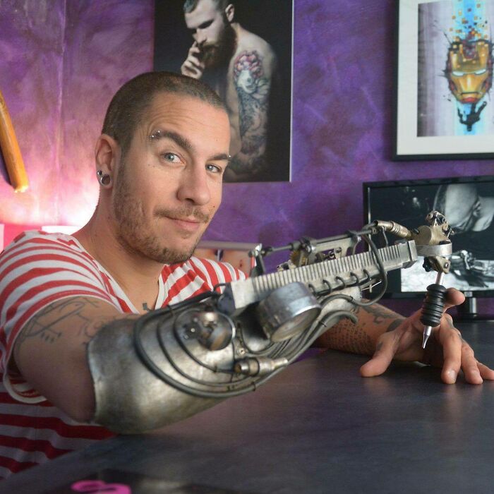 Este é Jc Sheitan Tenet, de Lyon, França. Ele é um tatuador amputado que usa uma pistola de tatuagem protética no trabalho.