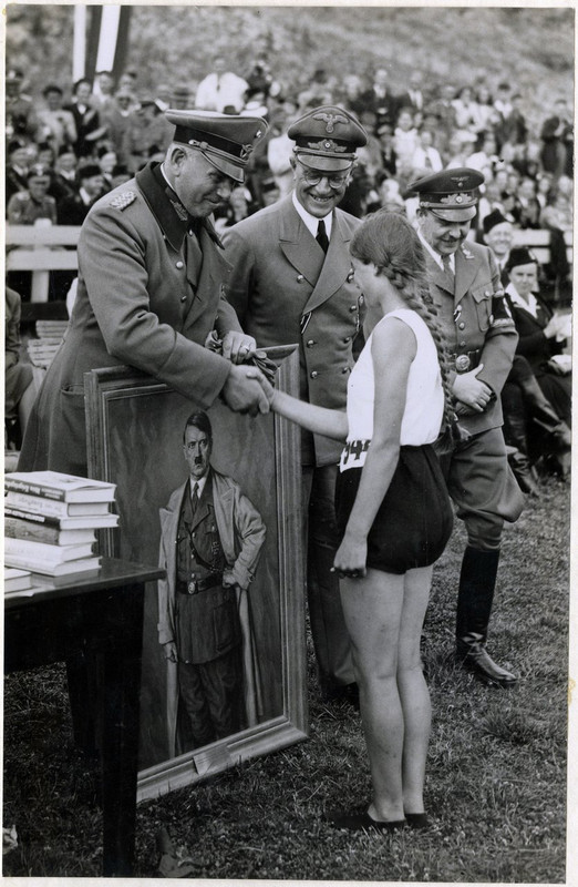 Um atleta holandês recebe um retrato de Adolf Hitler como prêmio esportivo, apresentado pelo general Otto Schumann, comandante de Ordnungspolizei. Haia, Holanda, 1941.
