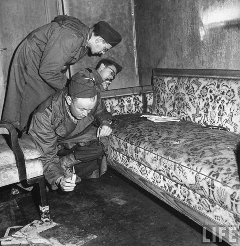 Soldados americanos inspecionam o sofá onde Adolf Hitler e Eva Braun cometeram suicídio, 1945.
