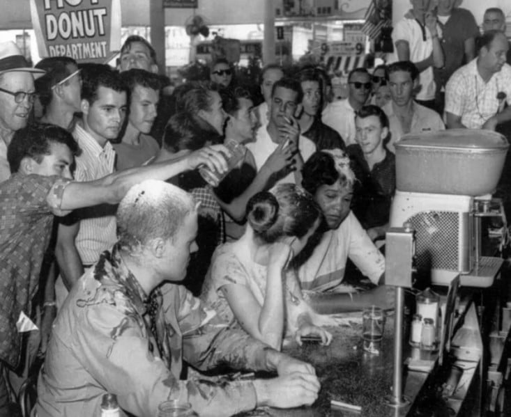Multidão despeja açúcar, ketchup e mostarda sobre as cabeças de (da esquerda para a direita) John Salter, Joan Trumpauer e Anne Moody durante manifestação em uma lanchonete 'somente para brancos' em Jackson, Mississippi - 28 de maio de 1963.