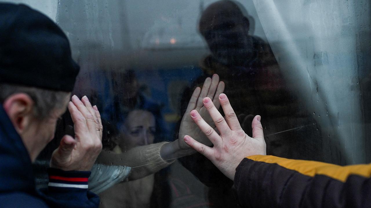 Um pai dá as mãos à sua família pela janela enquanto se despede deles em um trem de evacuação na estação central de trem de Odessa - 7 de março de 2022.