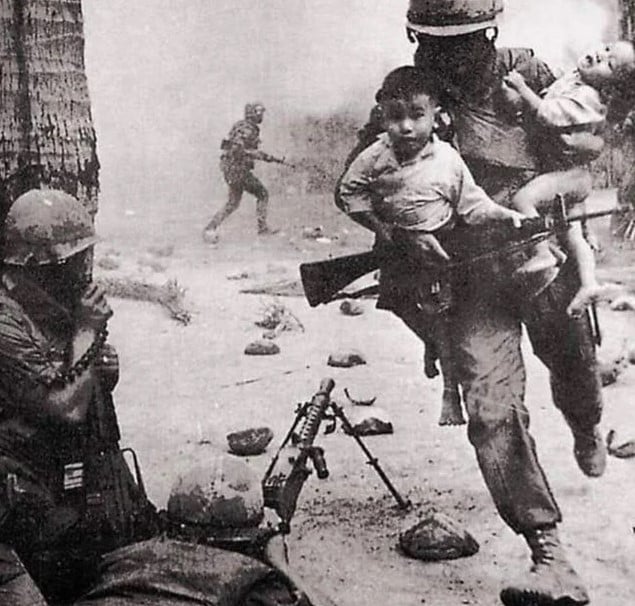 Soldado sul-coreano do 30º Regimento da Divisão Baekma resgatando duas crianças no meio de tiroteio, Vietnã, 27 de novembro de 1967.