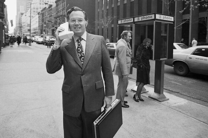 O primeiro rádio-telefone portátil, um Dynatac de 1973, sendo exibido pelo vice-presidente da Motorola, John F. Mitchell, em Nova Iorque