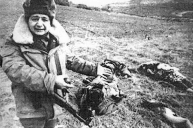 Soldado do Azebaijão cora e mostra os cadáveres de civis, incluindo crianças, que foram mortos pelo exército armênio em Khojaly, em 26 de fevereiro de 1992.