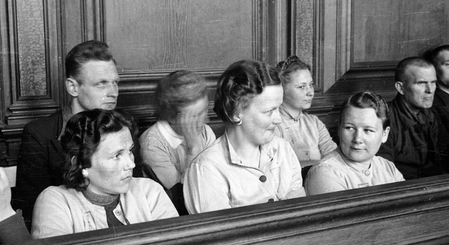 A superintendente do campo nazista Gerda Steinhoff (centro da foto) segura o sorriso ao ser julgada por torturar e assassinar prisioneiros. A maioria das superintendentes acusadas não levou o julgamento a sério. Elas riam e brincavam durante todo o processo - Polônia, 1946.