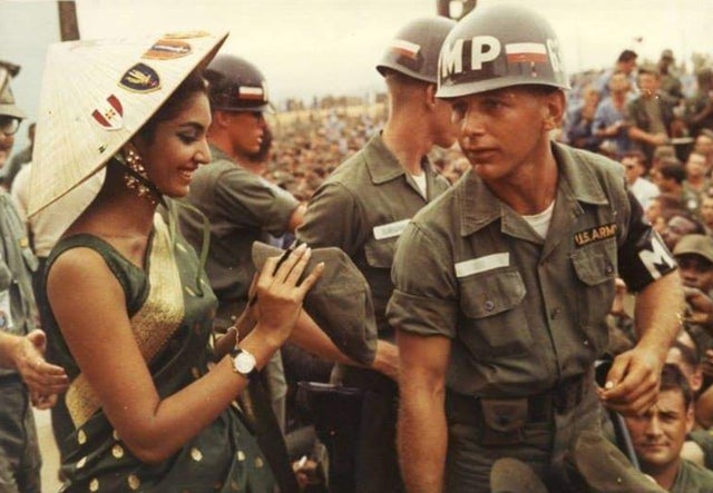 Miss Mundo Reita Faria (da Índia) assinando o boné de um soldado americano no Vietnã do Sul, 1966