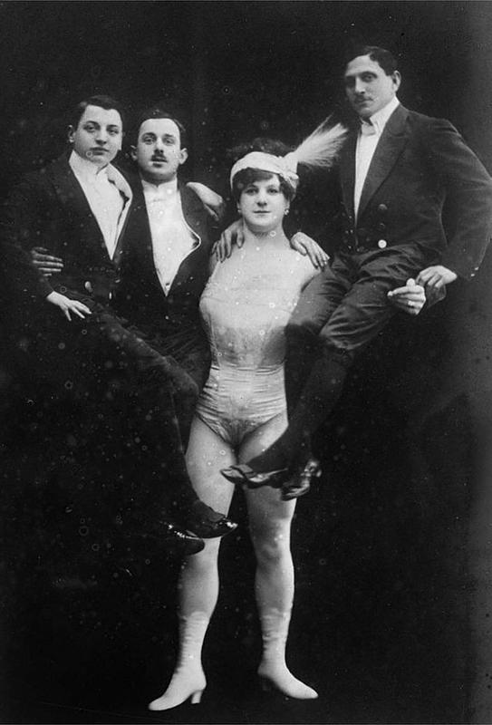 A mulher mais forte do circo Katie Sandwina, também conhecida como Lady Hércules, segurando três homens, em 1900. O fundo preto levanta suspeitas sobre a veracidade dessa força.