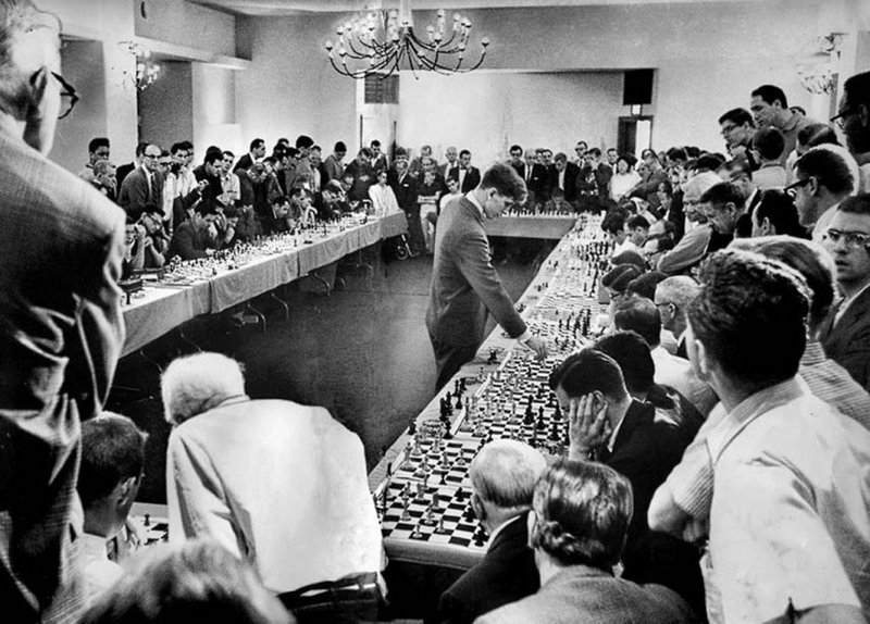 O prodígio do xadrez americano, Bobby Fisher, joga com 50 oponentes simultaneamente. Ganhou 47, perdeu 1 e empatou 2.