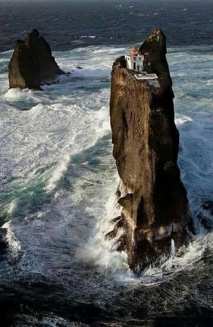 O farol mais isolado do mundo, o farol Þrídranaviti, empoleirado no topo de um pilar de rocha nas Ilhas Westman, na costa da Islândia