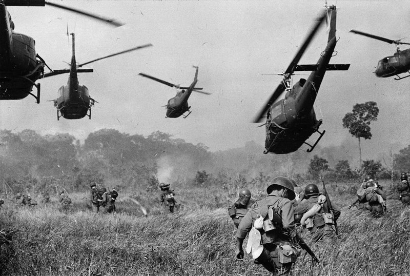 Helicópteros dos EUA lançam fogo na linha de árvores para cobrir o avanço das tropas sul-vietnamitas, 1965.