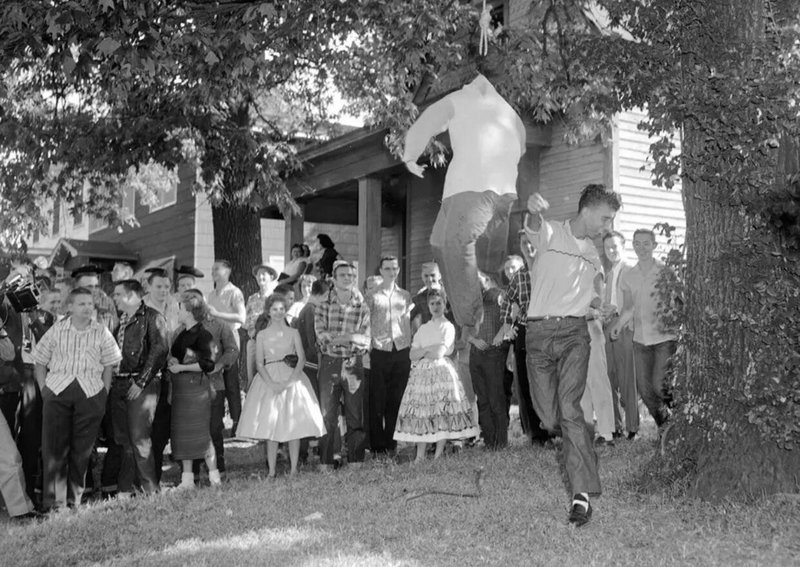 Estudante branco soca um boneco que simbolizava um estudante negro do lado de fora da Little Rock Central High School. Esta foto foi tirada depois que a escola foi forçada a dessegregar, um movimento que muitos moradores se opuseram veementemente, Arkansas, EUA, 1957.