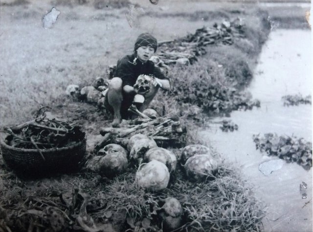 Mulher vietnamita lavando os ossos daqueles que morreram na grande fome de 1945, que matou 2 milhões de pessoas no Vietnã, antes de dar-lhes um enterro adequado.